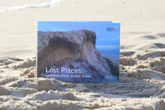 Buch Sylt Lost Places Geheimnisse einer Insel von Axel Link und Alex Lenz im Sand am Strand von Sylt